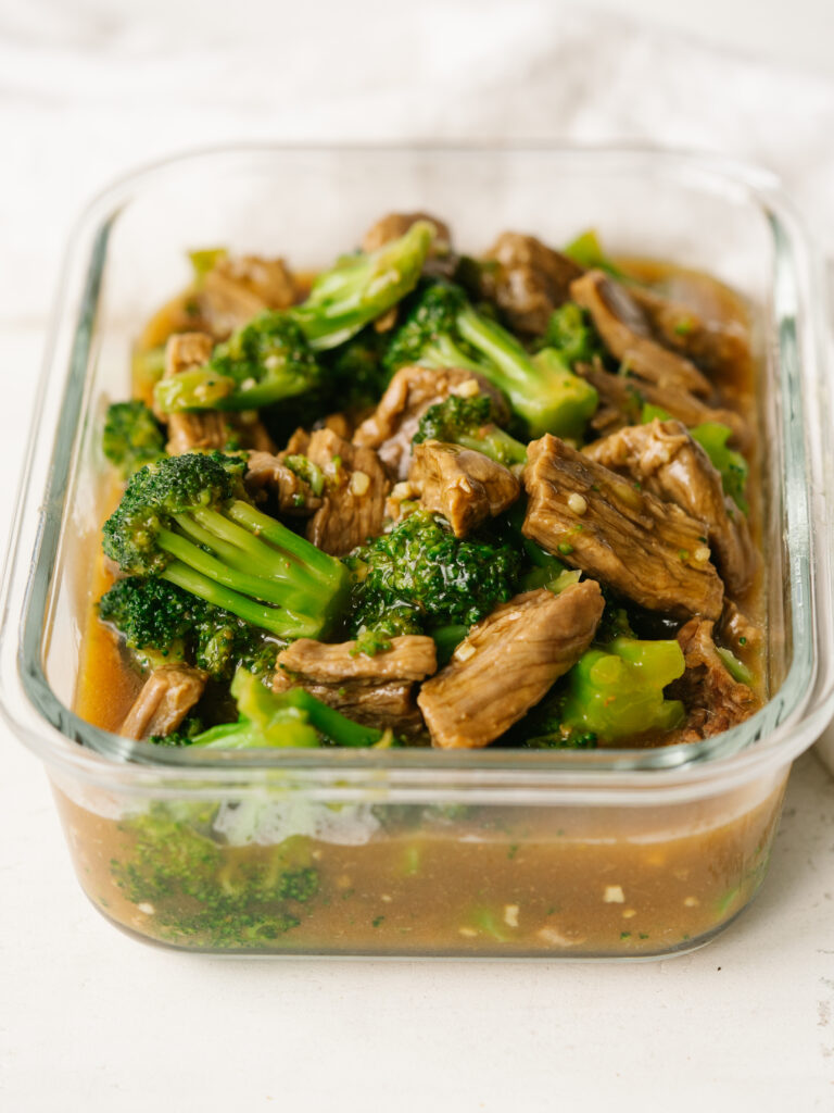 Three quarter view of easy beef and broccoli in a glass container