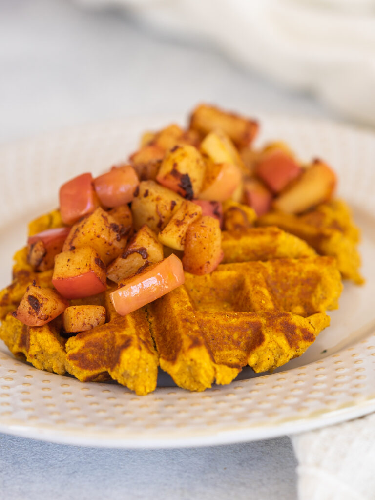 pumpkin spice waffles on a plate with cinnamon apples