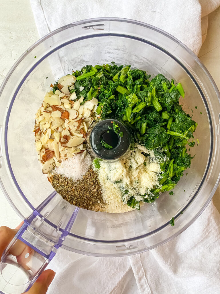 Ingredients for a budget friendly kale pesto in a food processor