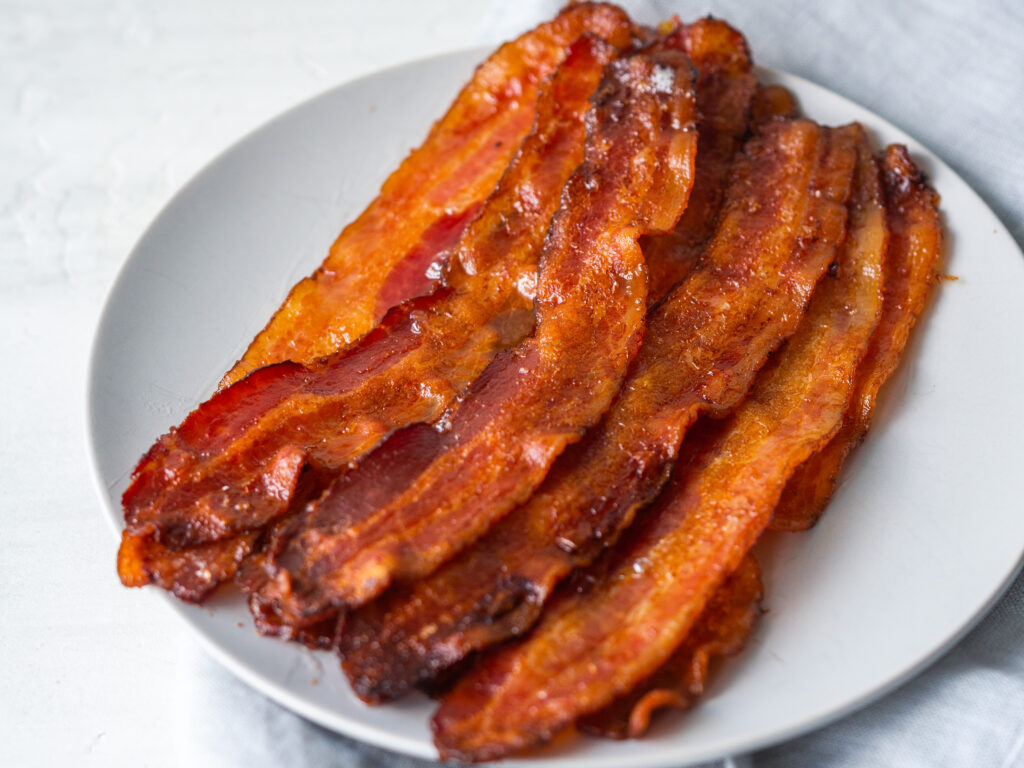Three quarter view of crispy bacon slices on a plate