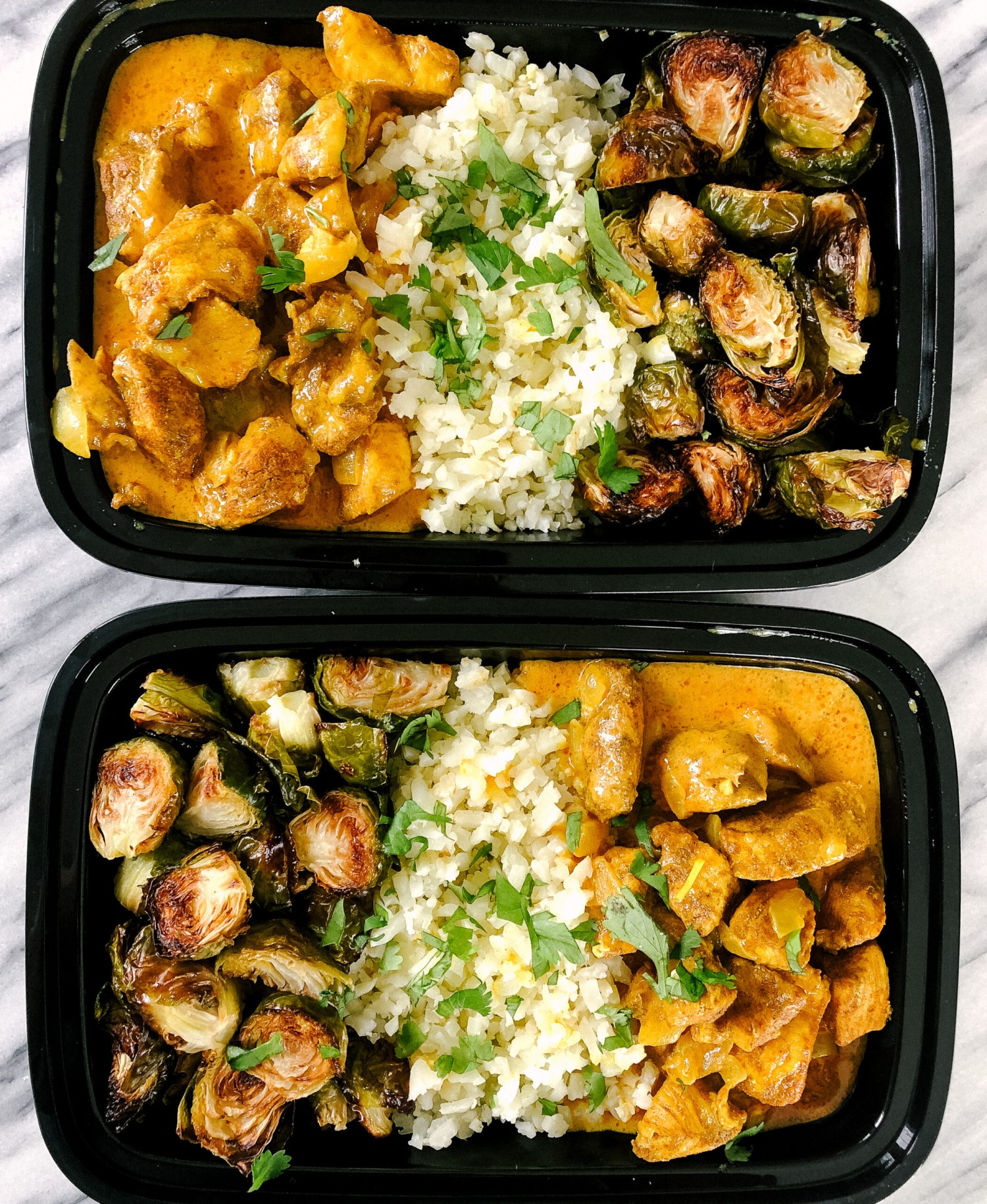 Above view of butter chicken in meal prep containers