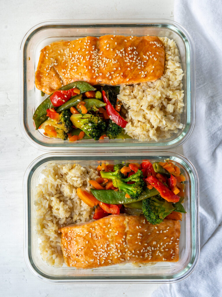 sheet pan salmon dinner with rice in meal prep containers