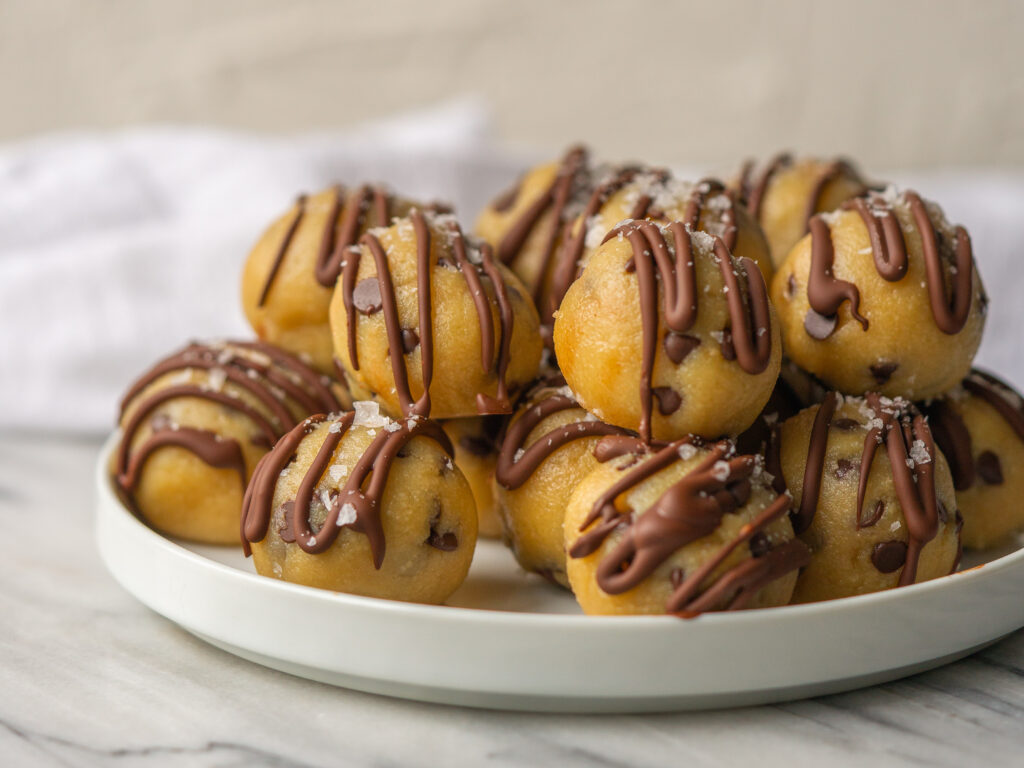 side view of a plate of healthy cookie dough rolled into bite size balls