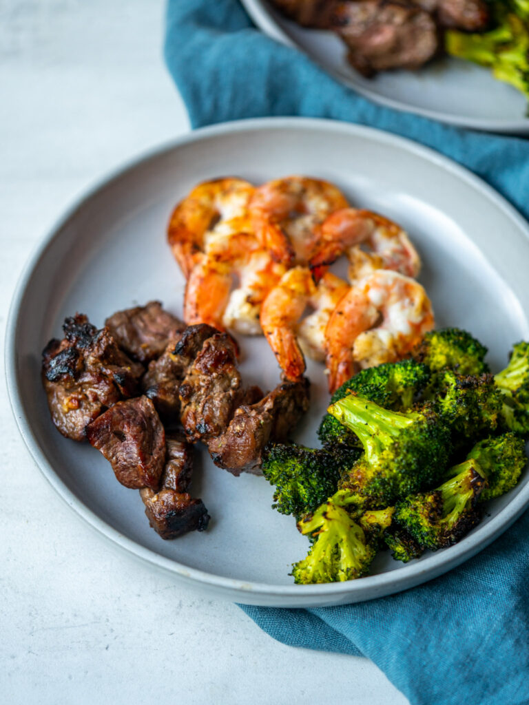 Marinated grilled steak and shrimp served with grilled broccoli