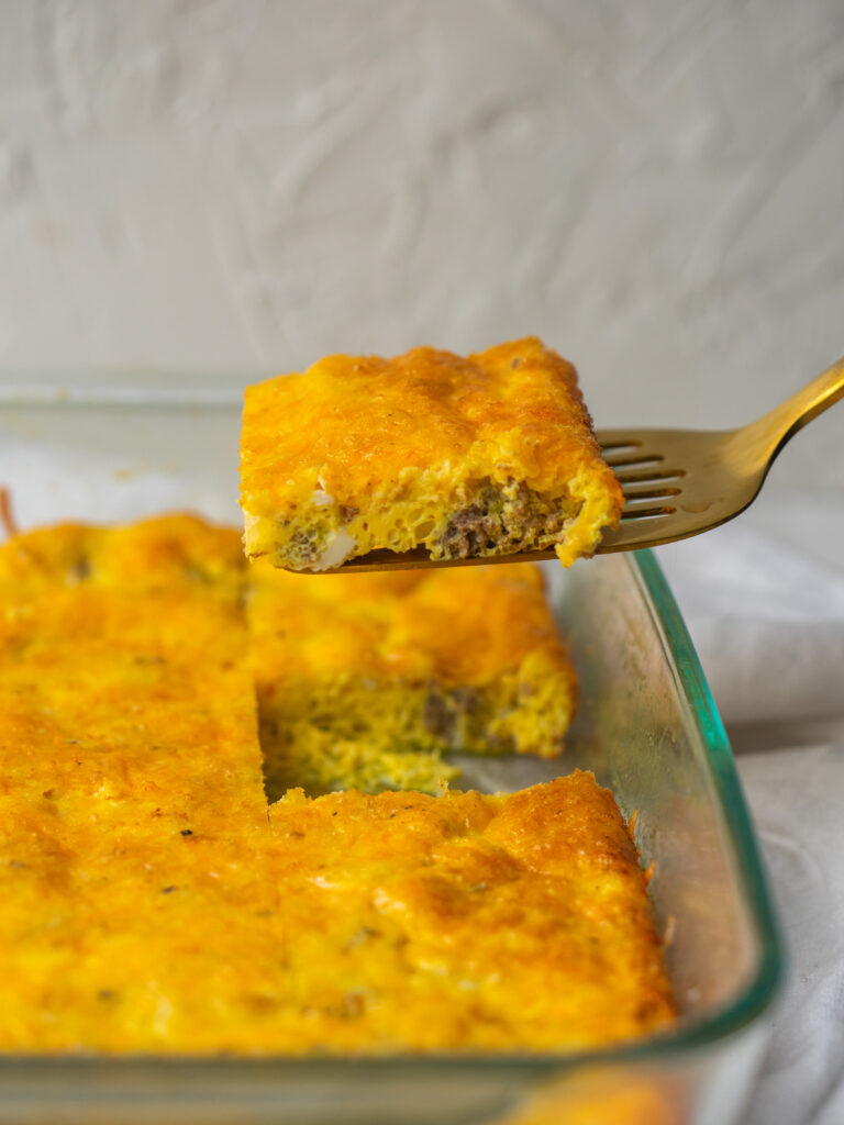 side view of a slice of cheeseburger breakfast casserole being pulled out of the pan