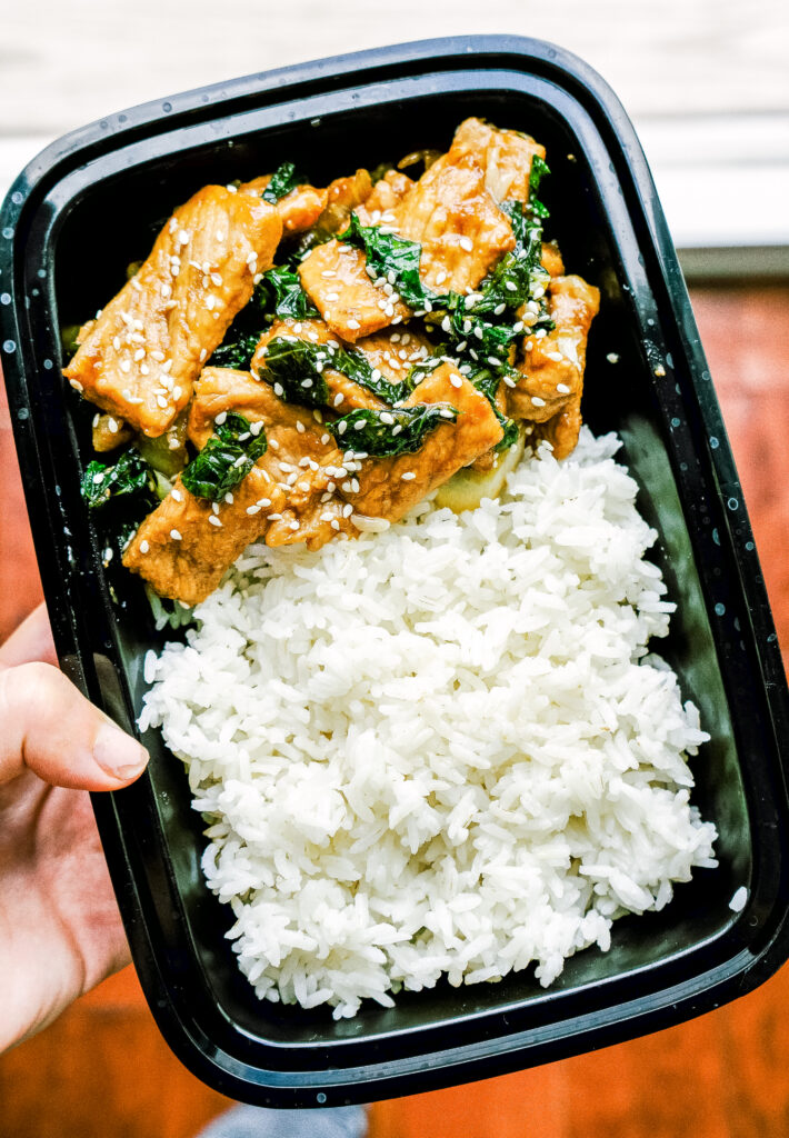 Above view of teriyaki pork in a takeout container