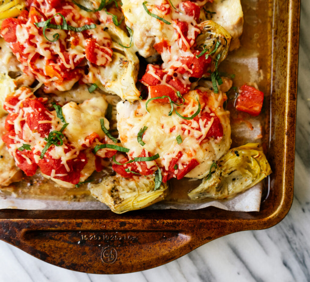 Close up above view of sheet pan tomato and artichoke chicken
