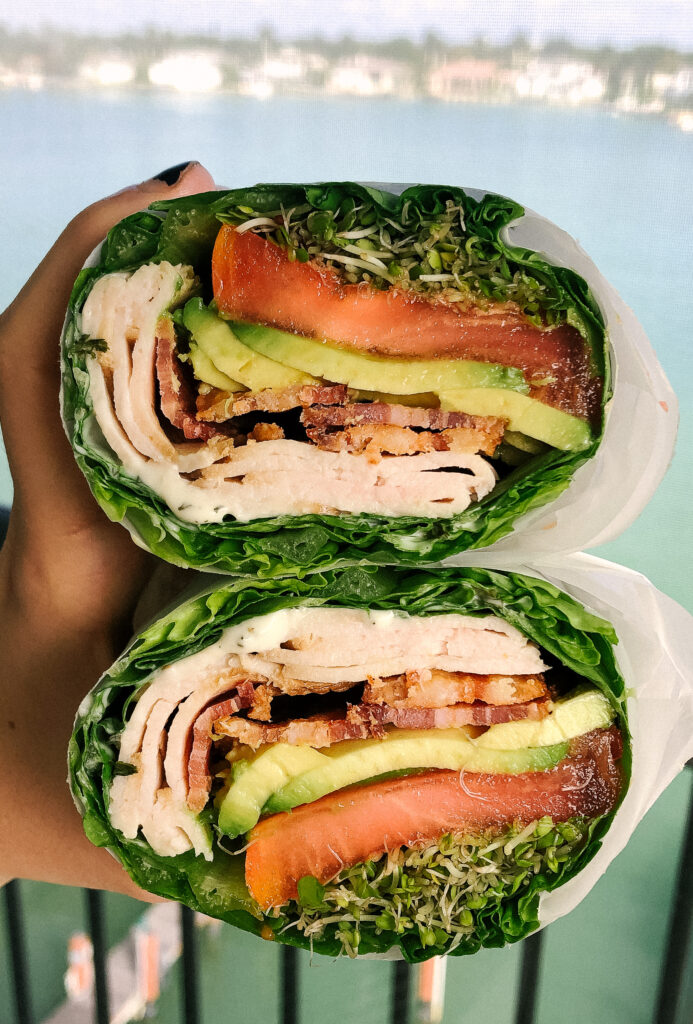 a turkey club sandwich wrapped in romaine lettuce instead of bread