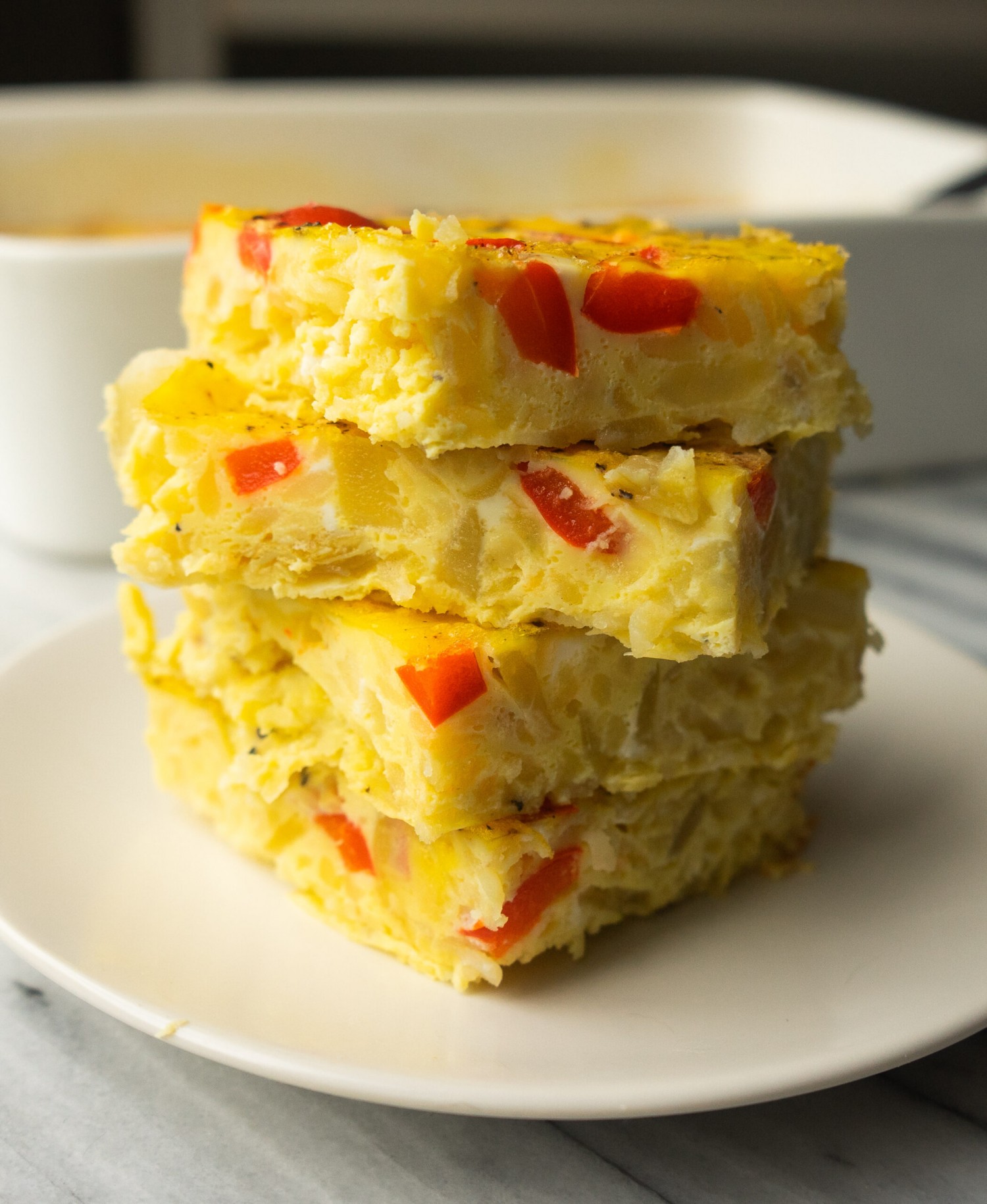 Side view of slices of hashbrown breakfast casserole on a plate