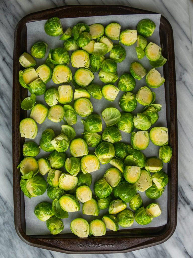 Above view of cut brussels sprouts on sheet pan