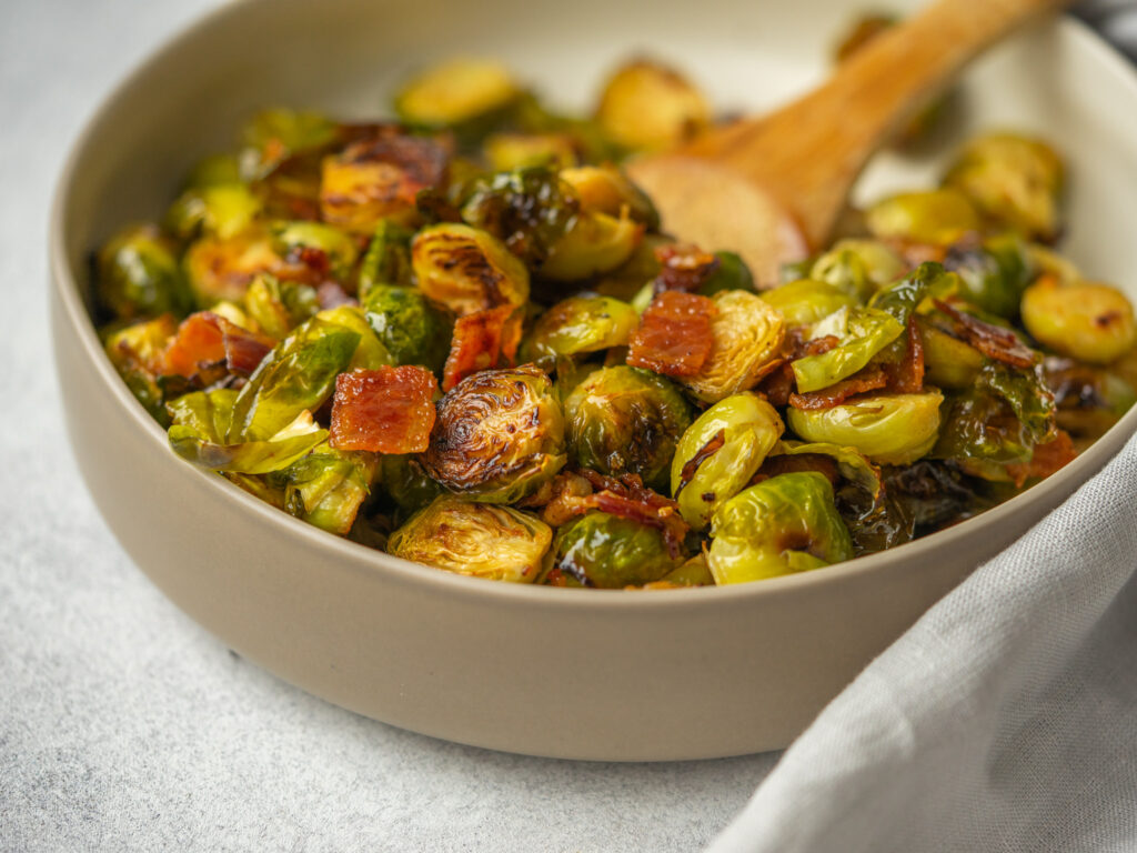 Three quarter view of maple bacon brussels sprouts in a serving bowl