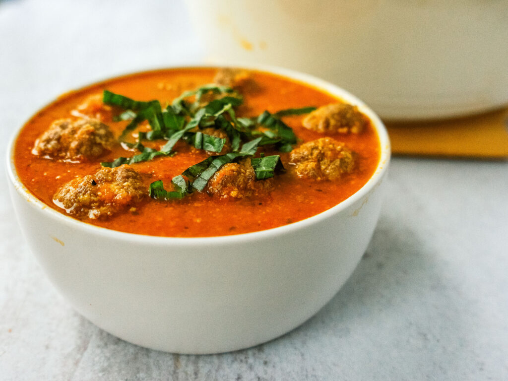 Three quarter view of a bowl of meatball soup
