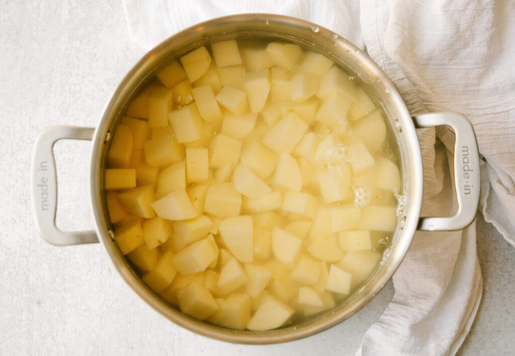 Cubed russet potatoes in a stock pot covered with water