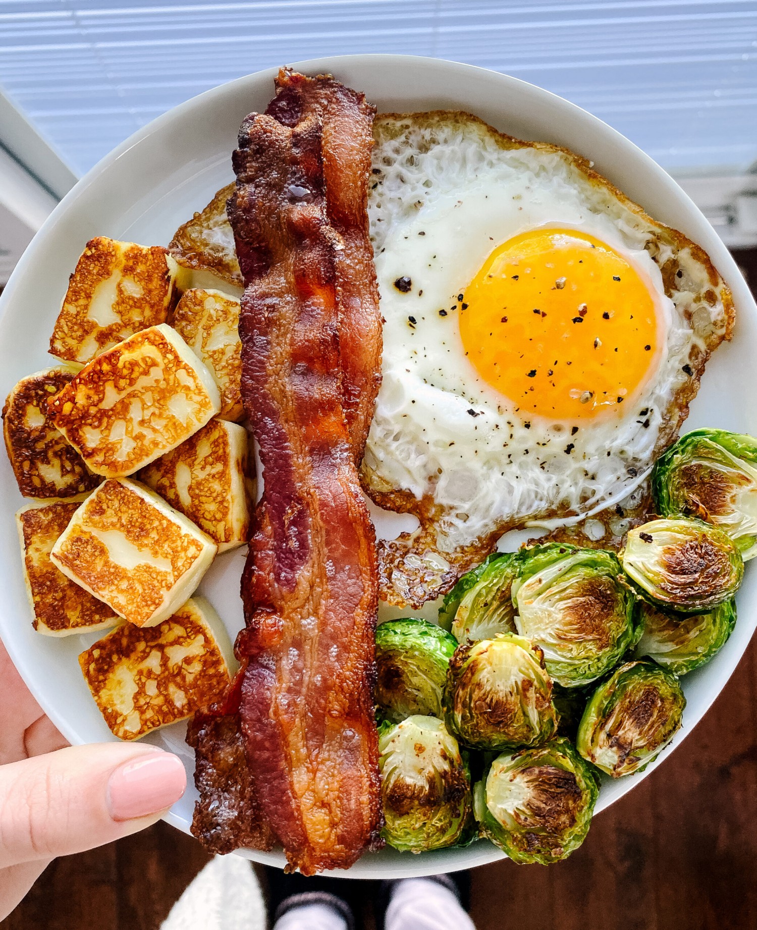 Above view of a breakfast plate with eggs, bacon and roasted brussels sprouts