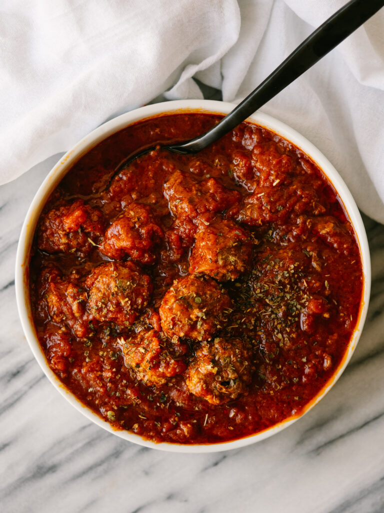 Above view of Easy Instant Pot Meatballs in a serving bowl with a spoon in it 