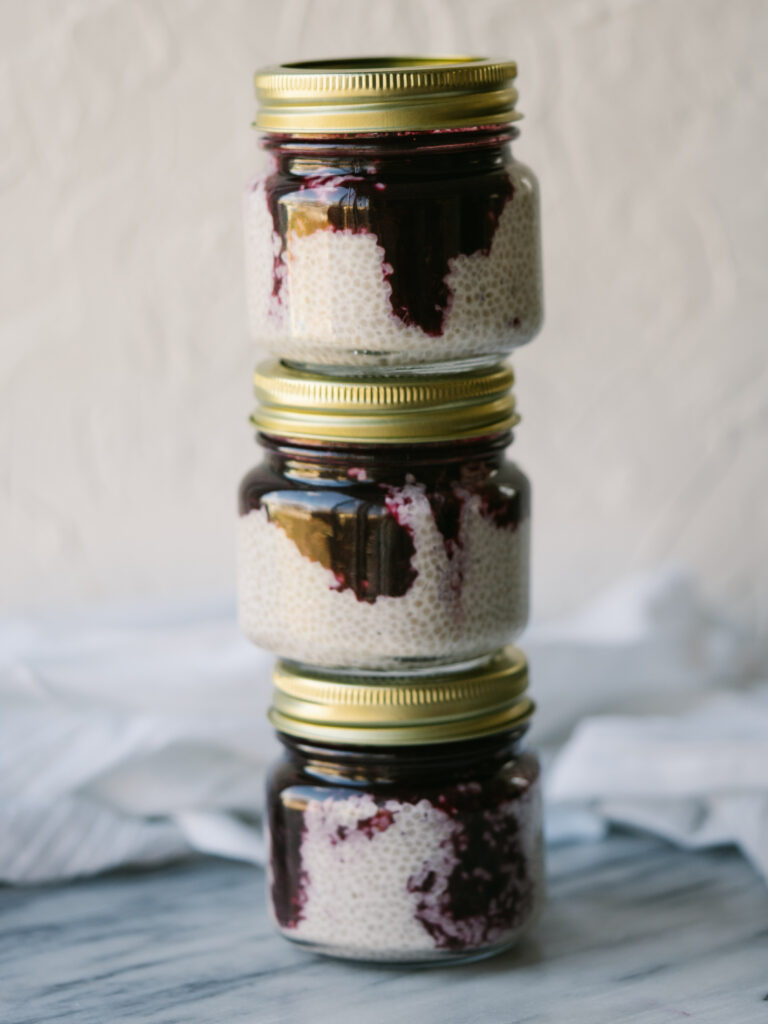 Side view of three jars of blueberry coconut chia seed pudding