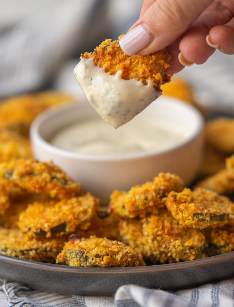 close up view of fried pickles in air fryer dipped in some homemade ranch