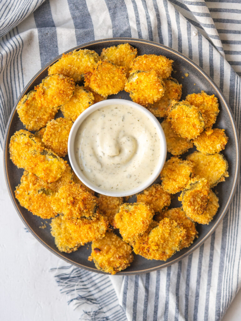 above view of air fryer pickles on a plate with homemade ranch dressing