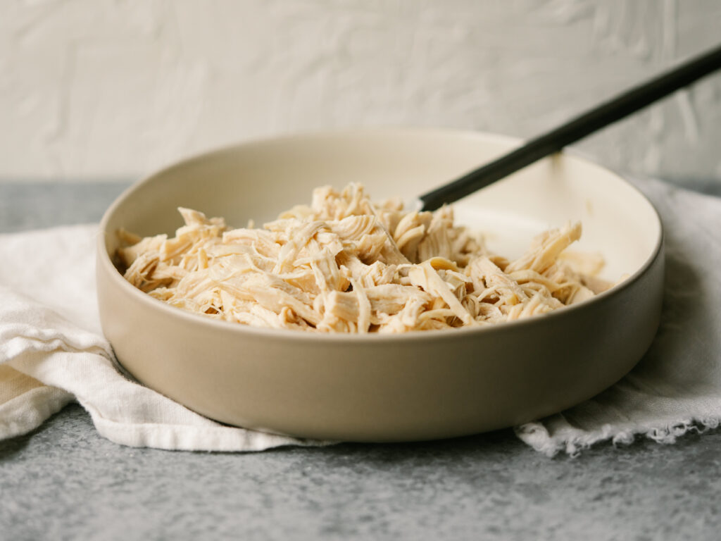 three quarter view of a bowl of instant pot shredded chicken