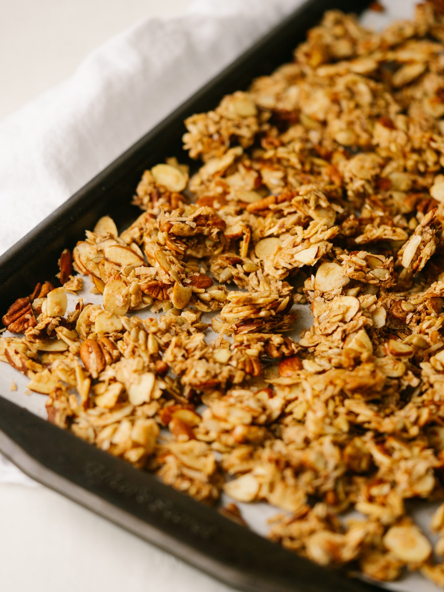 Grain free granola cooling on a sheet pan that is lined with parchment paper