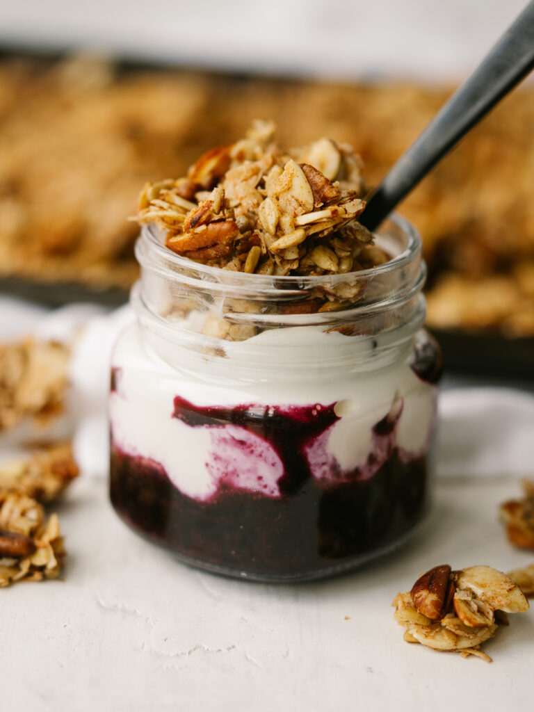 Side view of yogurt and blueberries topped with grain free granola