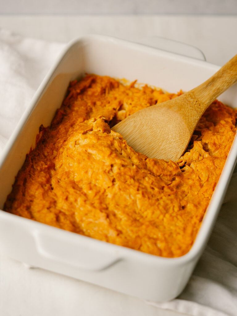 Three quarter view of a serving spoon in a pantry buffalo chicken dip