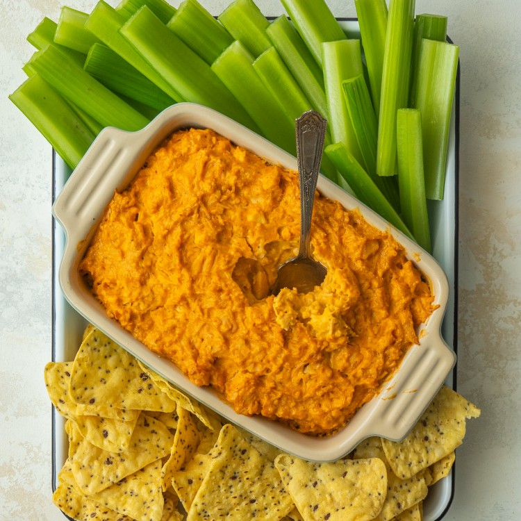 Above view of pantry buffalo chicken dip served with celery and tortilla chips