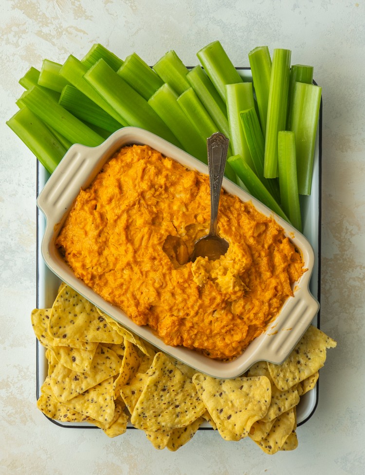 Above view of pantry buffalo chicken dip served with celery and tortilla chips