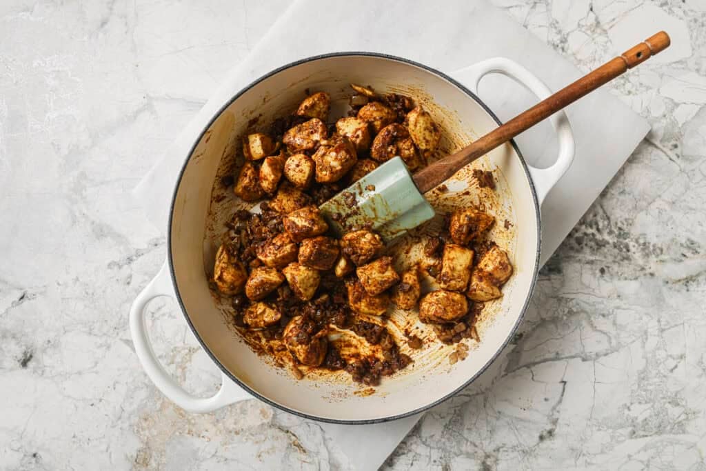 seasoned chicken being cooked in a skillet