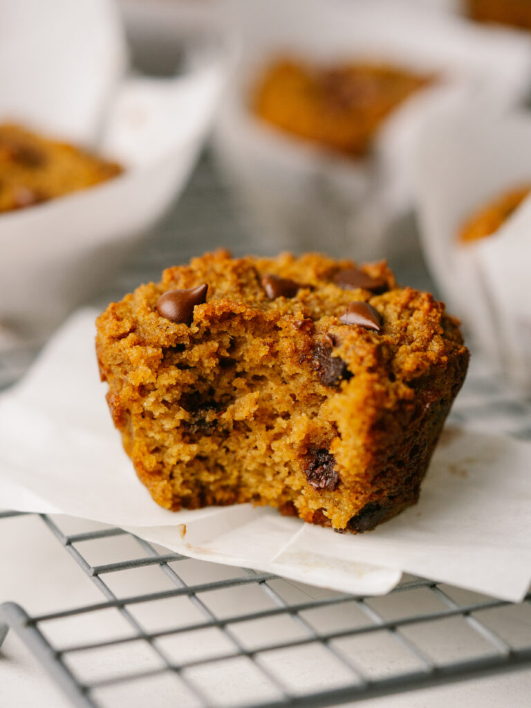 Side view of  a pumpkin chocolate chip muffin on a cooling rack