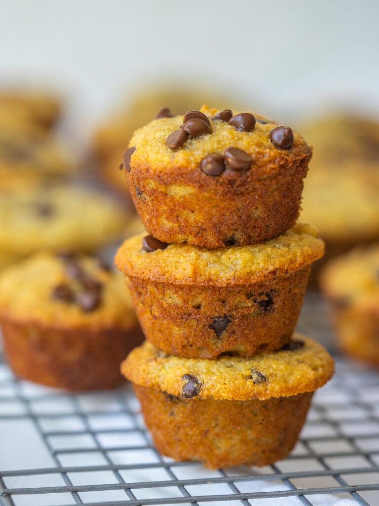 Side view of mini banana muffins stacked on a cooling rack