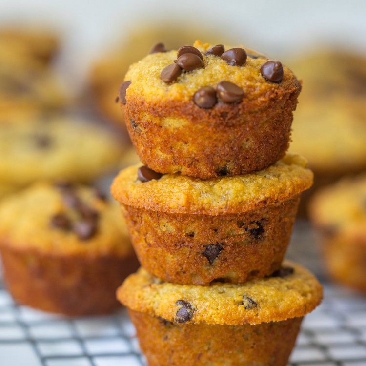 Side view of mini banana muffins stacked on a cooling rack