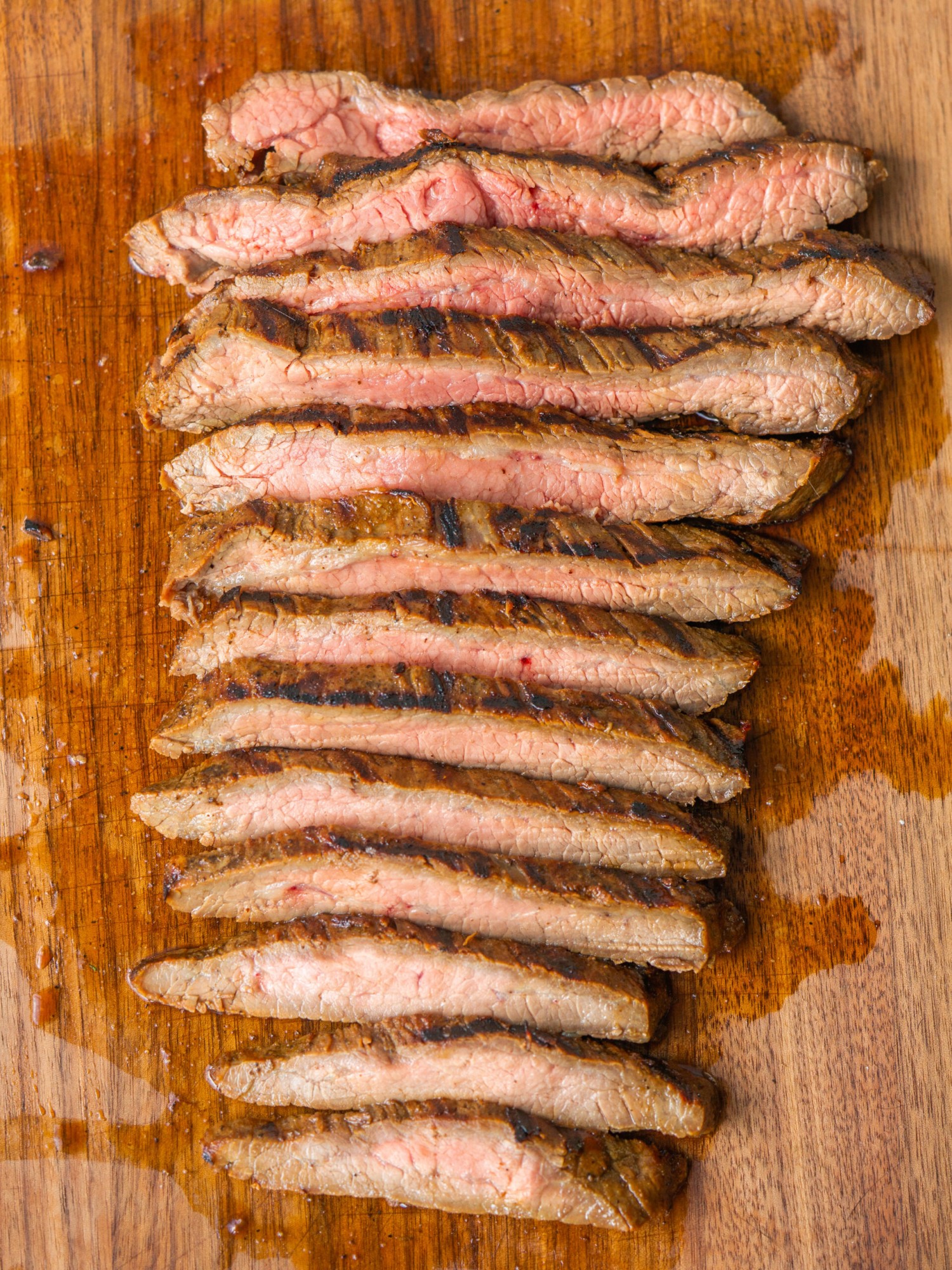 Sliced grilled flank steak on a cutting board