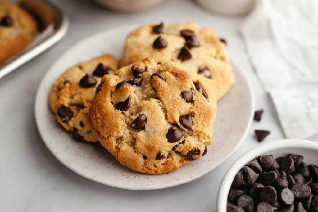 three grain free chewy chocolate chip cookies on a plate