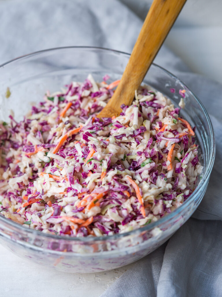 Three quarter view of a large serving bowl of creamy coleslaw