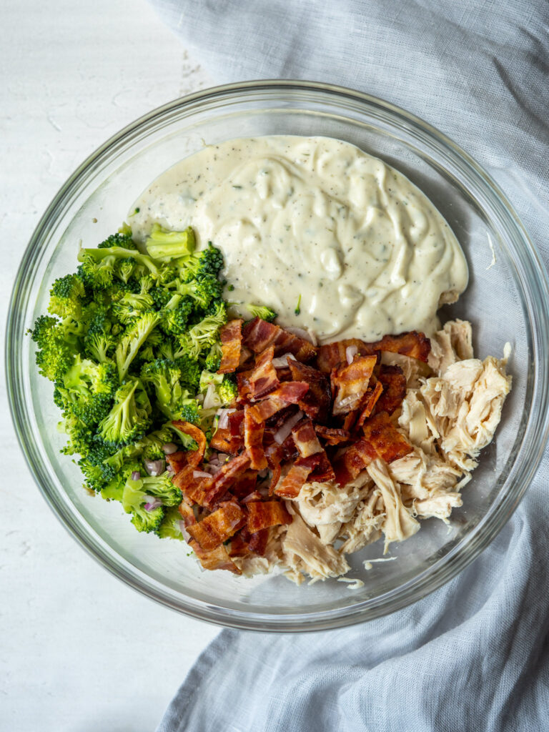 Ingredients for a chicken bacon ranch salad in a mixing bowl