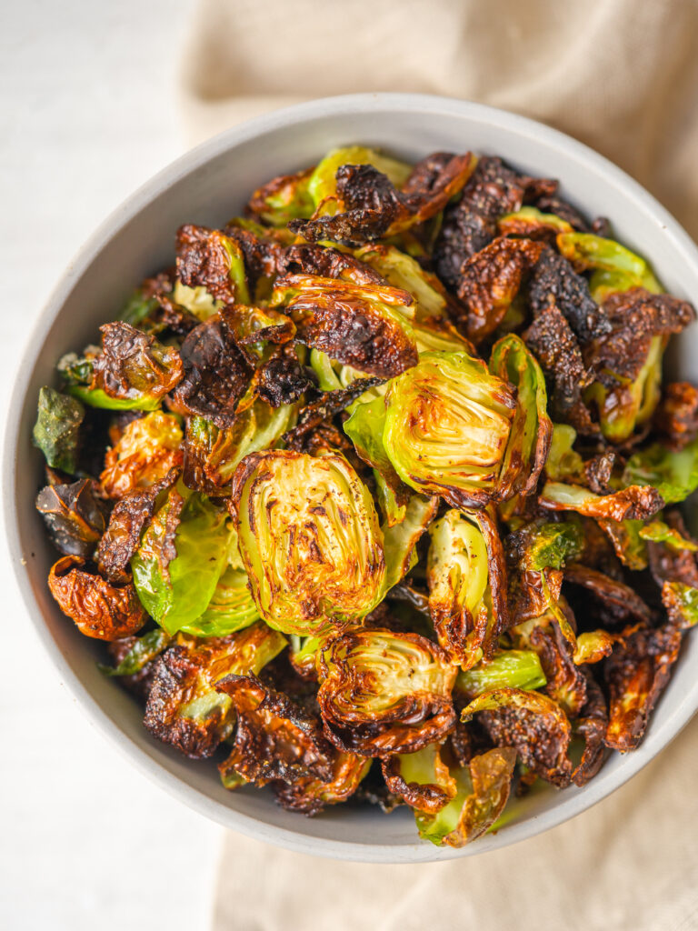 Above view of crispy air fryer brussels sprouts in a bowl.
