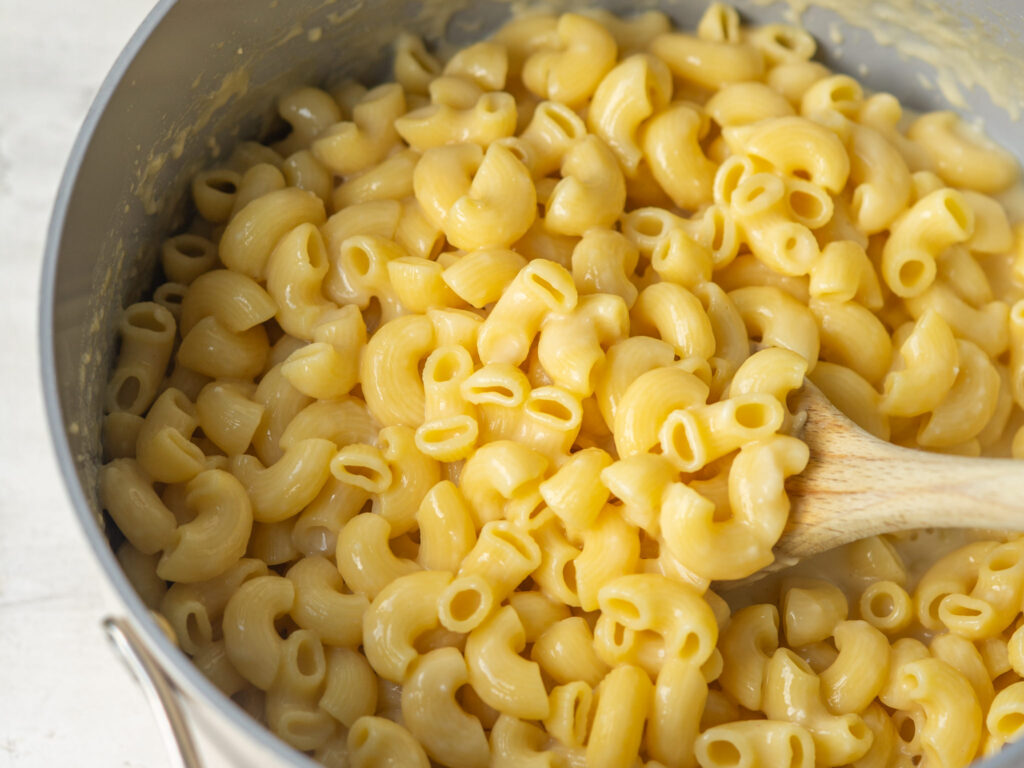 Above view of creamy one pot mac and cheese serve with a wooden spoon