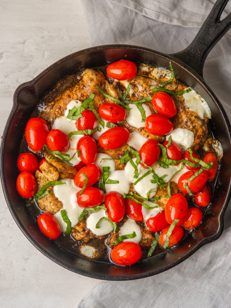 Above view of balsamic caprese chicken in a cast iron skillet