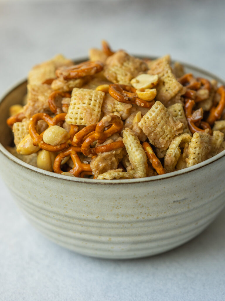 Side view of a sweet and salty chex mix in a serving bowl