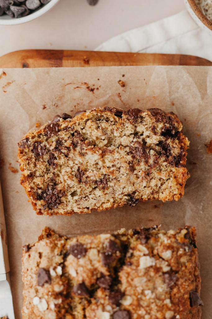 Above view of a sliced of oatmeal banana bread with chocolate chips on a cutting board