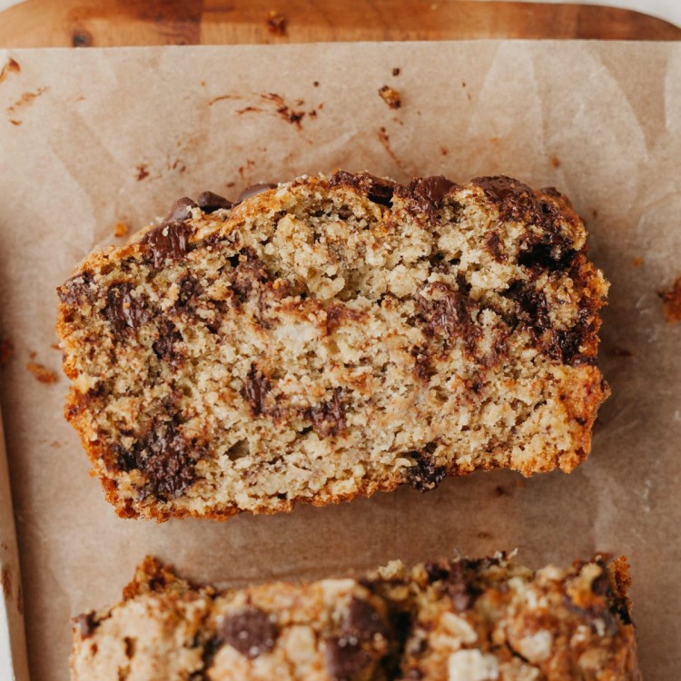 Above view of a sliced of oatmeal banana bread with chocolate chips on a cutting board