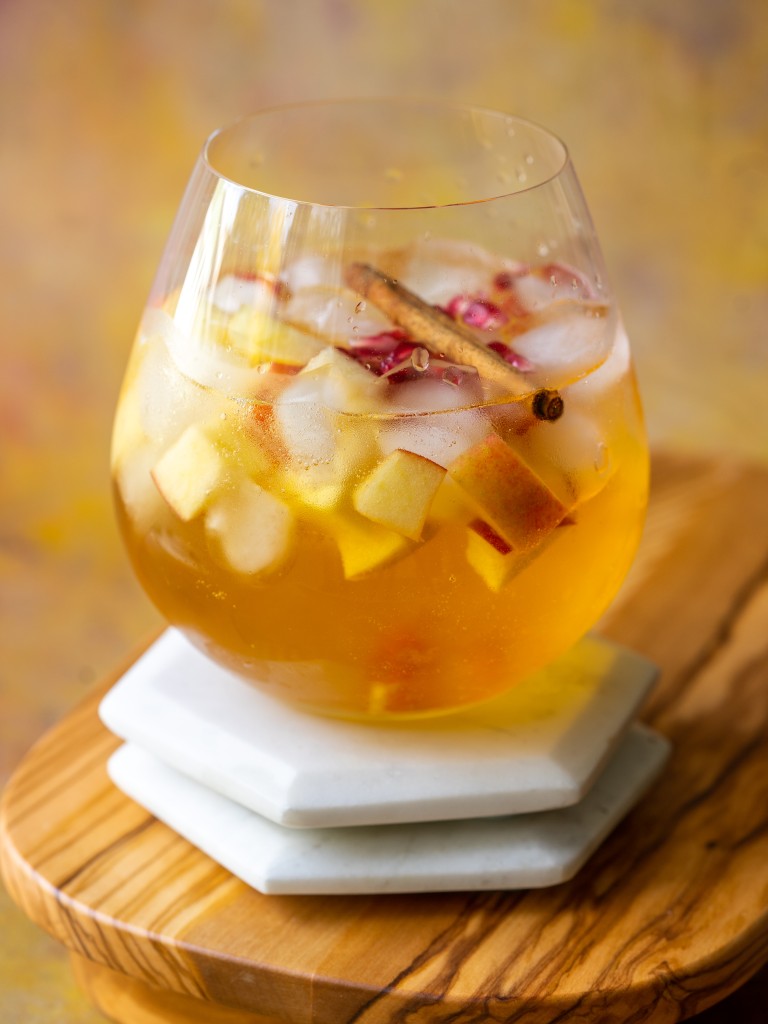 Side view of an apple cider sangria in a serving glass