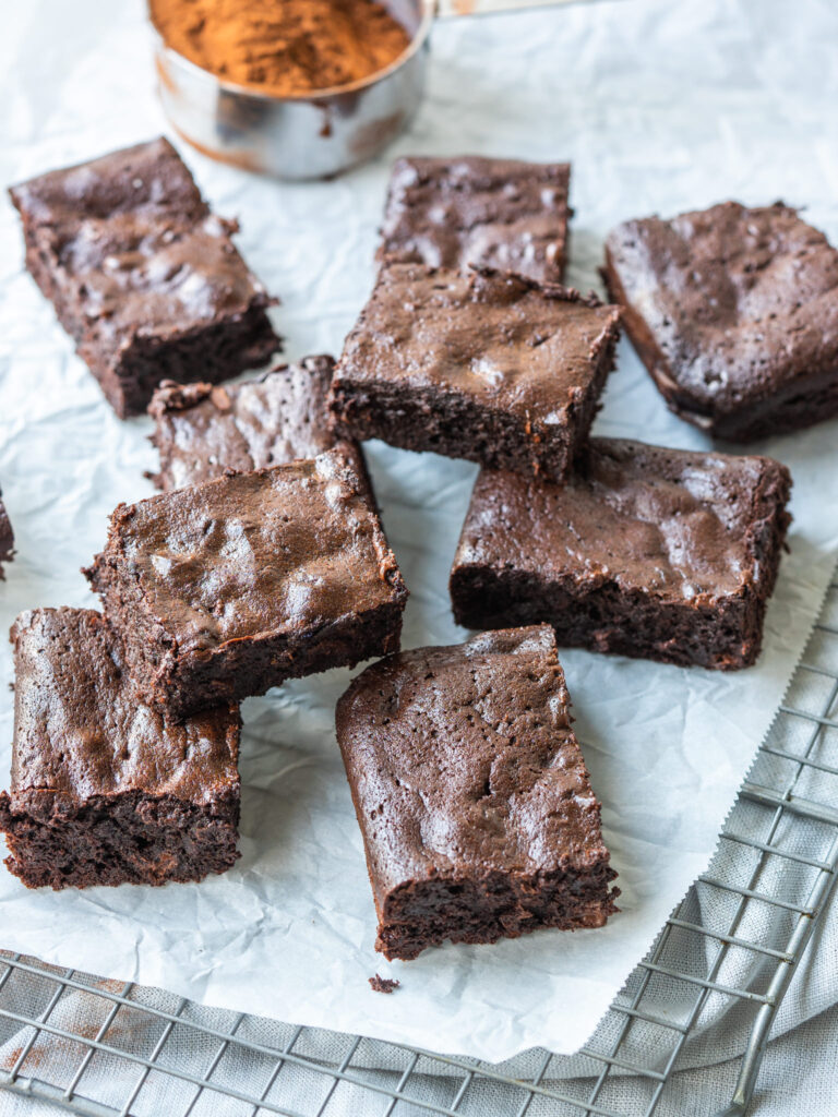 Three quarter view of flourless brownies cut into squares on a cooling rack