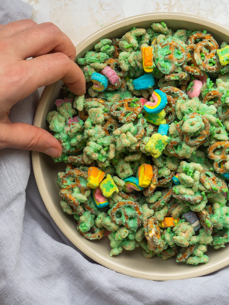 Above view of a hand grabbing a handful of Leprechaun snack mix