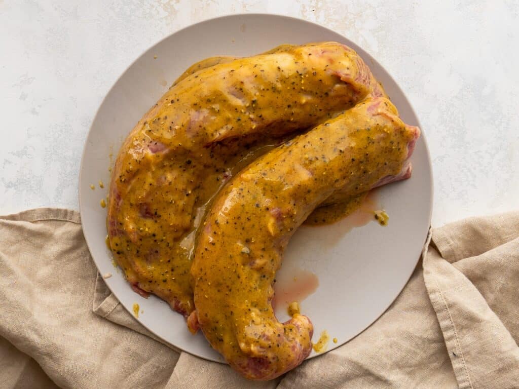 two pork tenderloins covered in a brown sugar dijon marinade