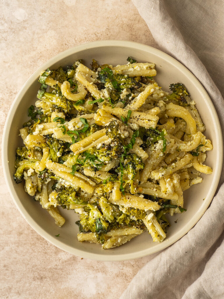 above view of a bowl of cheesy broccoli pasta with lemon