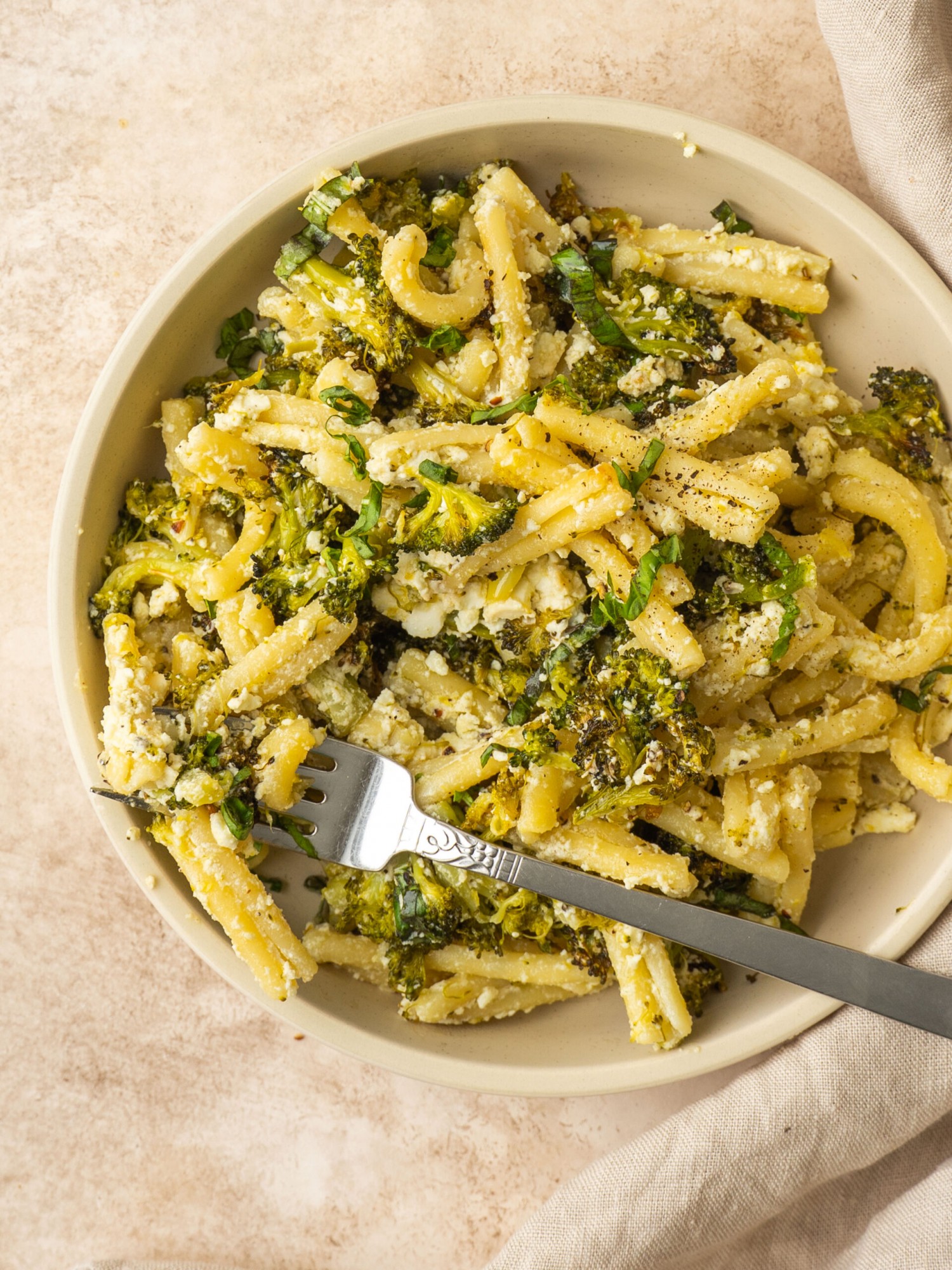 Broccoli pasta made with creamy feta in a small serving bowl with a fork in it