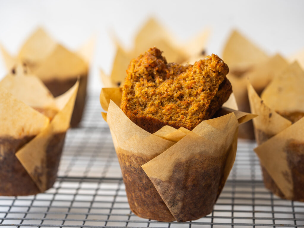 Side view of gluten free carrot cake muffins on a cooling rack