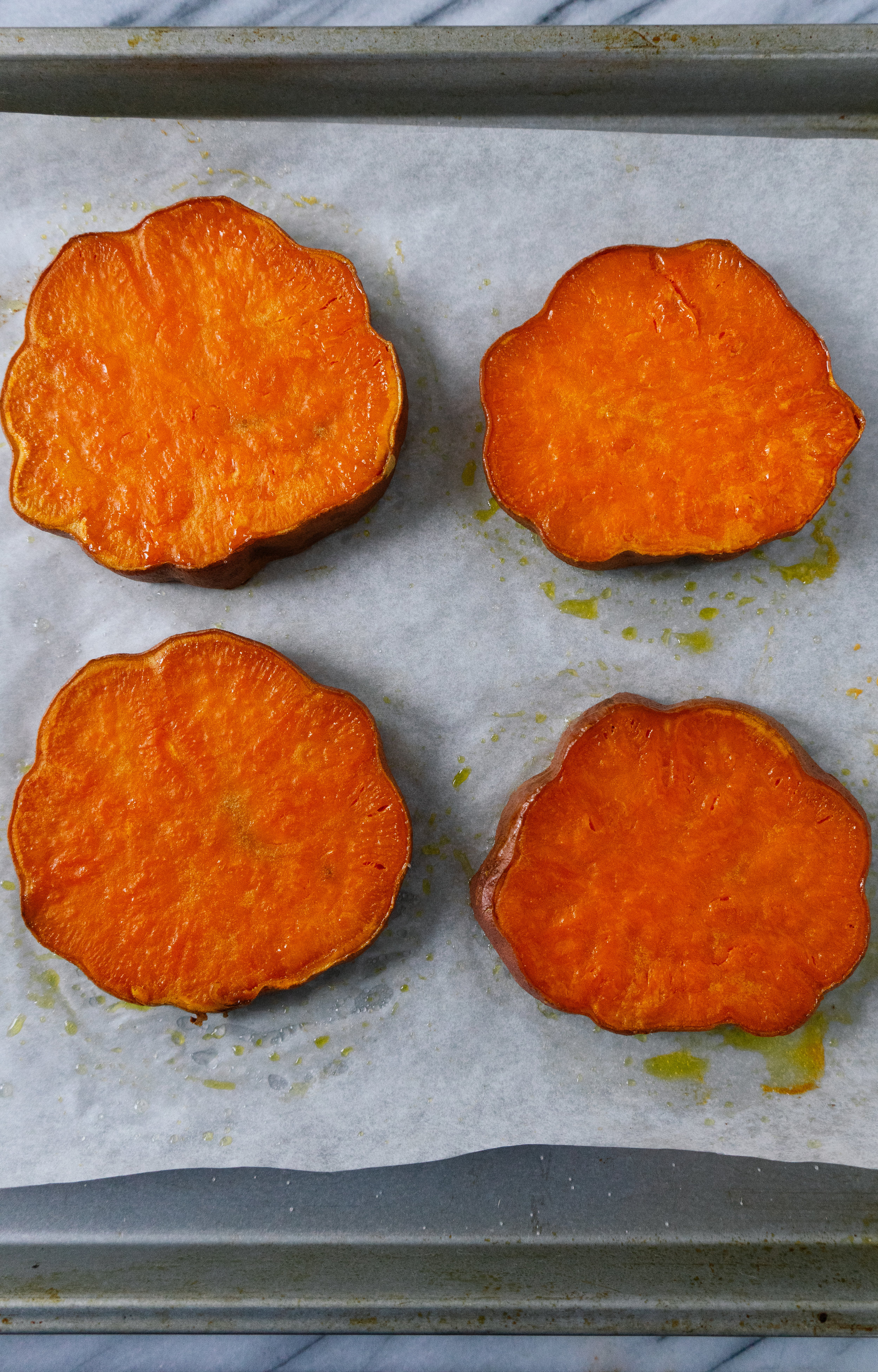 Above view of roasted sweet potato buns on a baking sheet
